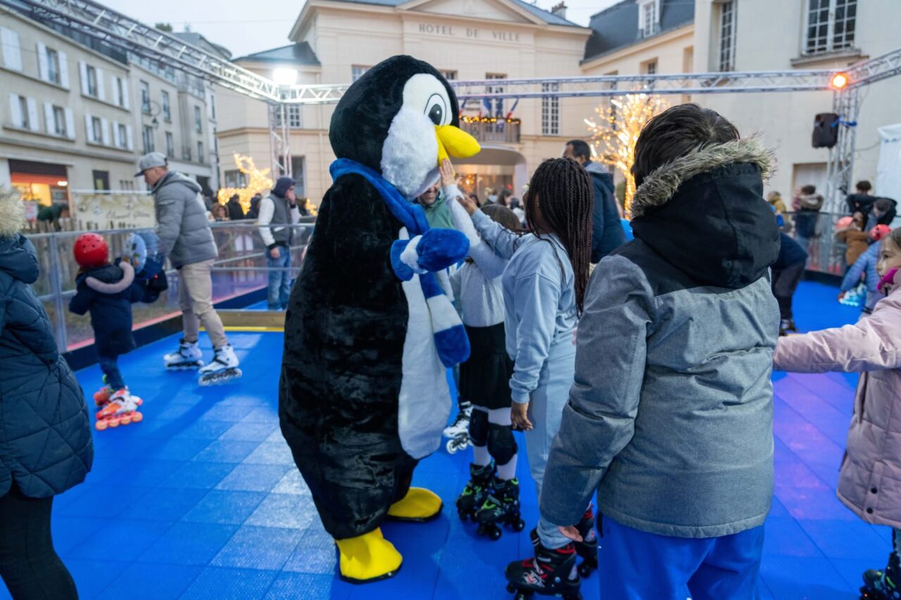 Mascotte pingouin sur piste de roller