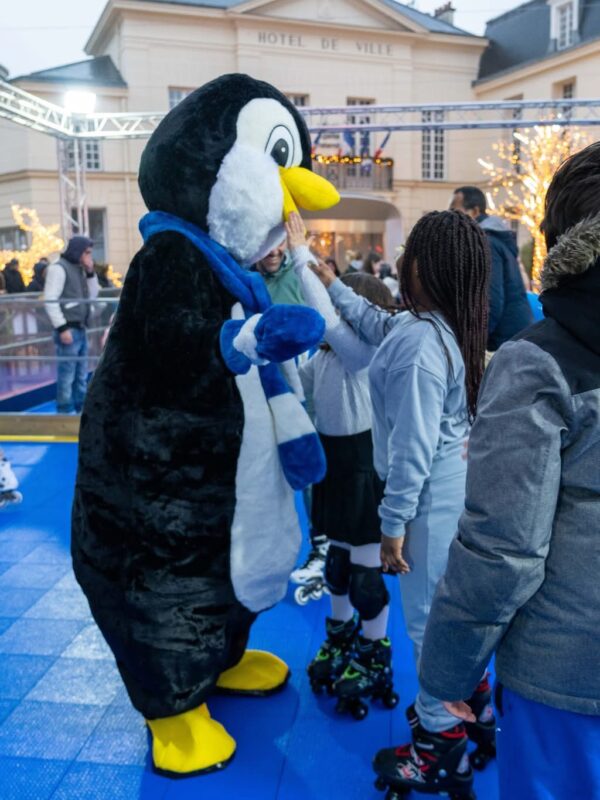 Mascotte pingouin sur piste de roller