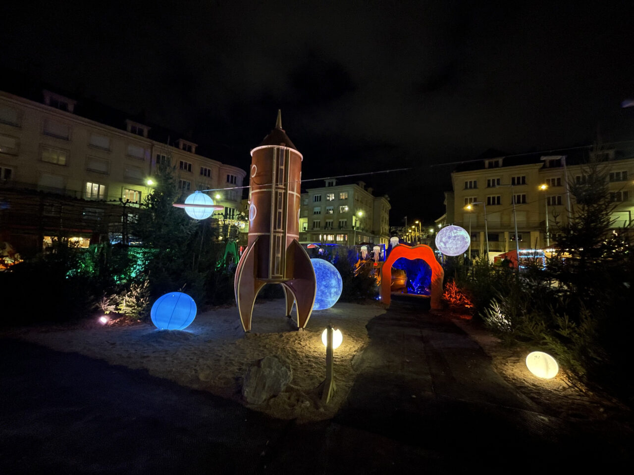 scénographie de nuit avec une fusée et des planètes éclairées