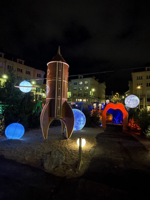 scénographie de nuit avec une fusée et des planètes éclairées