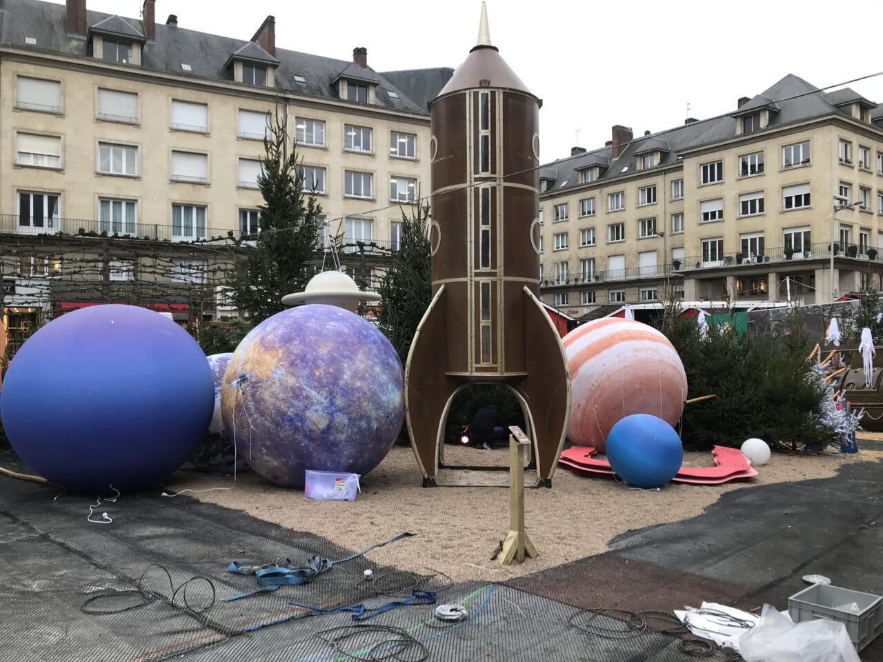 scénographie en centre ville avec une fusée et des planètes
