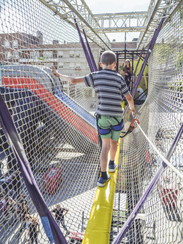 enfant traversant le pont de singe de la tour Indiana